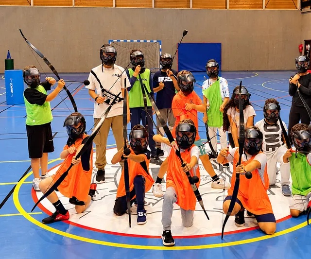 Groupe d'enfants casqués avec leurs arcs dans le gymnase du Kremlin-Bicêtre