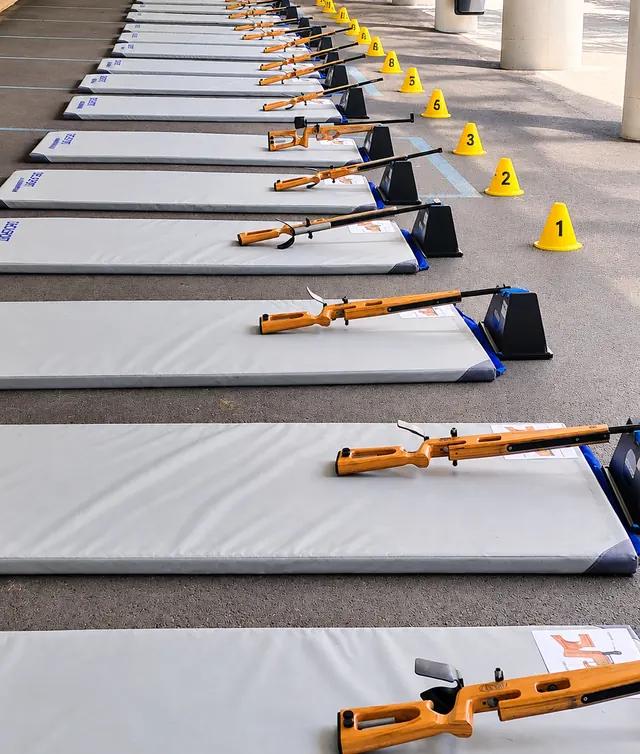 Tapis alignés et carabines laser sur une dalle