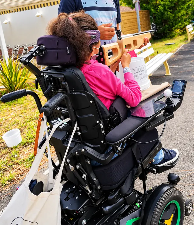 Personne en fauteuil roulant participant à une animation de tir laser